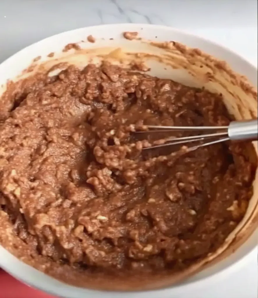 Layering strawberry mixture over chocolate overnight oats in mason jar